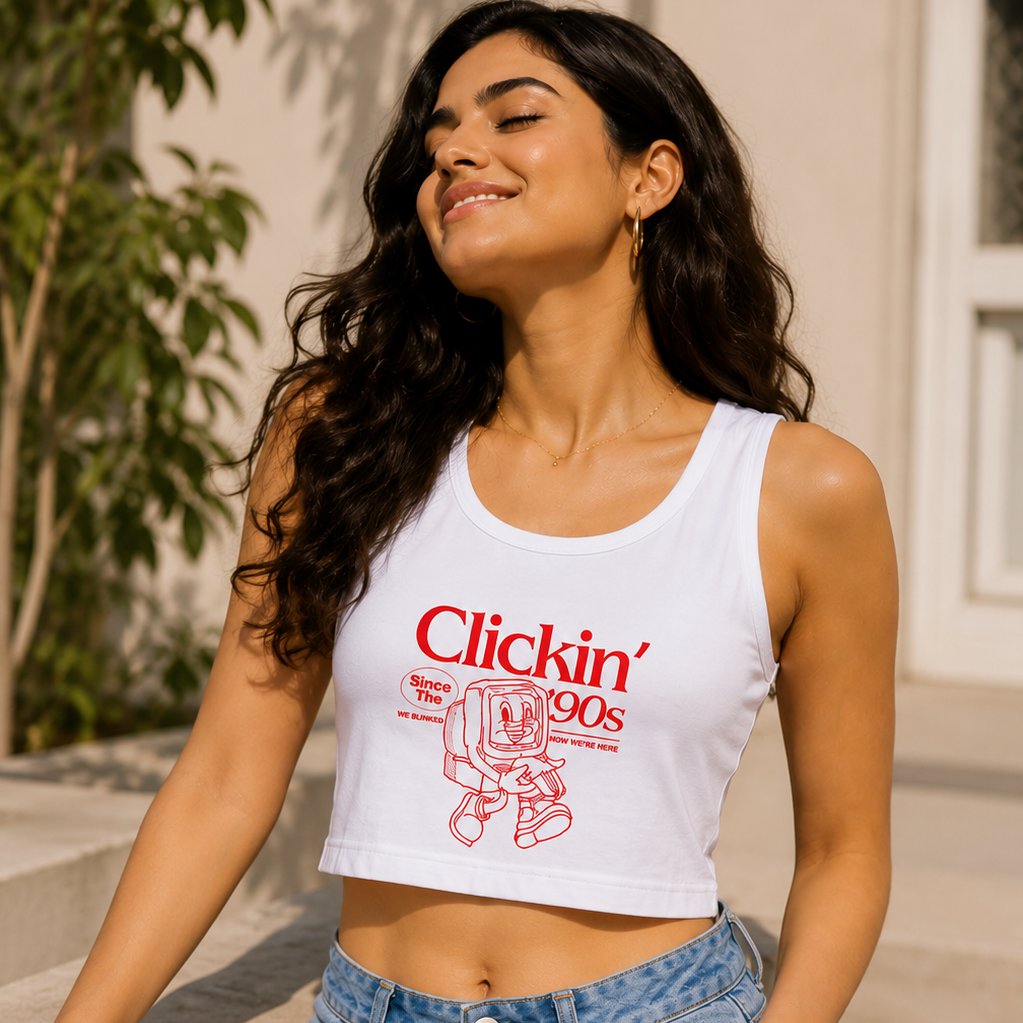 Woman wearing a white tank top with red text and blue jeans, standing outdoors.